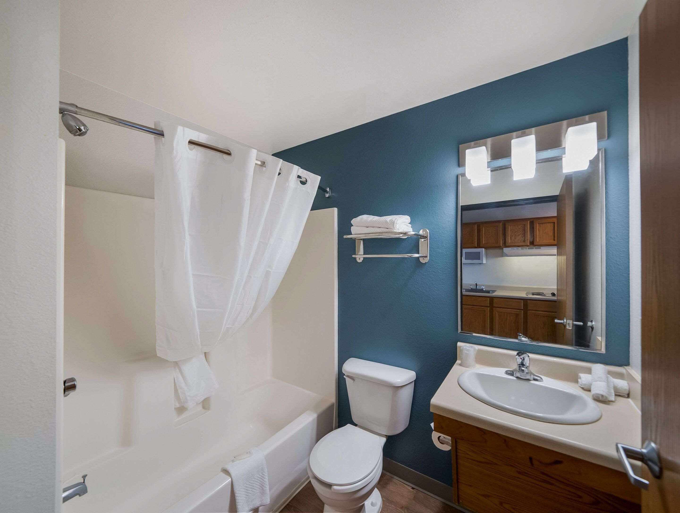 Une salle de bain équipée d’une baignoire, de toilettes, d’un lavabo et d’un miroir avec éclairage.