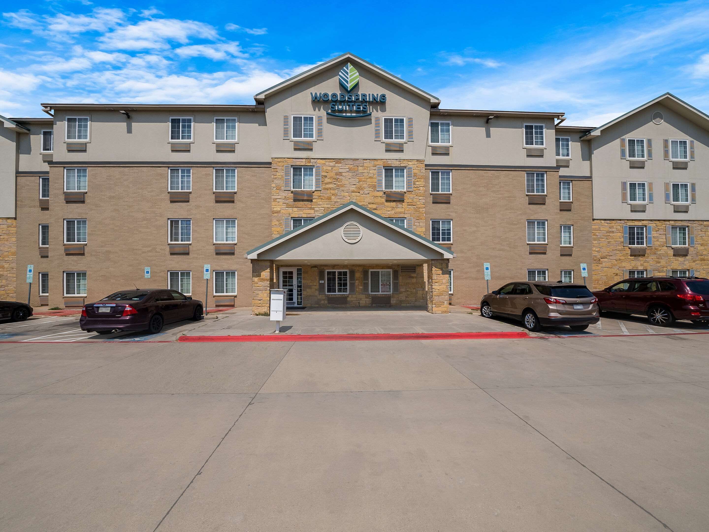 A multi-story hotel with a stone facade and a central entrance.