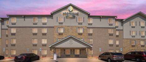A multi-story hotel with a stone facade and a central entrance.