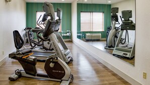 A gym with treadmills, stationary bikes, and a mirrored wall. - Holiday Inn Express Hotel & Suites Jacksonville by IHG (Jacksonville)