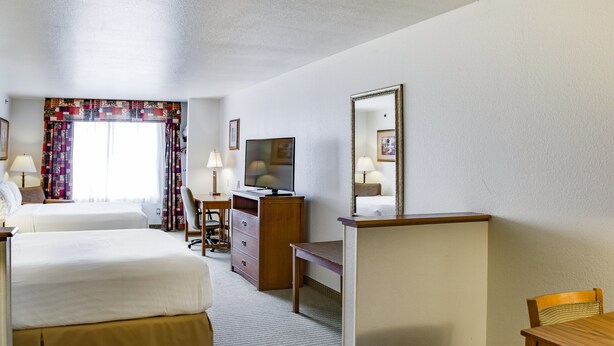 A hotel room with two beds, a desk, a television, and a mirror. - Holiday Inn Express Hotel & Suites Jacksonville by IHG (Jacksonville)