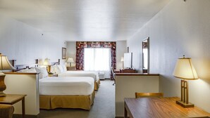 A hotel room with a bed, two bedside tables, a desk, a chair, a lamp, a mirror, and a window with curtains. - Holiday Inn Express Hotel & Suites Jacksonville by IHG (Jacksonville)