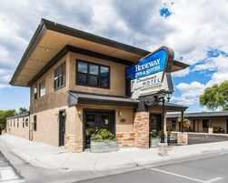Un edificio de dos pisos con un letrero que dice 'RODEWAY INN & SUITES The Douthsauener MOTEL'.