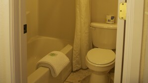 A small, compact bathroom with a bathtub, toilet, and shower curtain. - Rodeway Inn & Suites Williams Downtowner - Rte 66 (Williams)