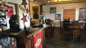 A bar area with a counter, wooden chairs, and various wall decorations including stars and signs. - Rodeway Inn & Suites Williams Downtowner - Rte 66 (Williams)