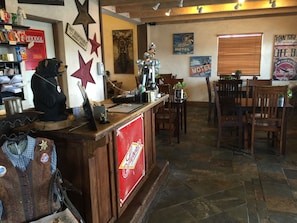 A bar area with a counter, wooden chairs, and various wall decorations including stars and signs. - Rodeway Inn & Suites Williams Downtowner - Rte 66 (Williams)