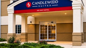 Exterior do hotel Candlewood Suites, com entrada em destaque e visão clara das portas de acesso.