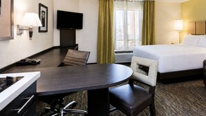 A hotel room with a bed, a desk, a chair, a television, and a telephone. - Candlewood Suites Pearl by IHG (Pearl)