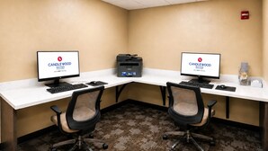 A hotel room with two desks, each with a computer and keyboard, and two office chairs. - Candlewood Suites Pearl by IHG (Pearl)