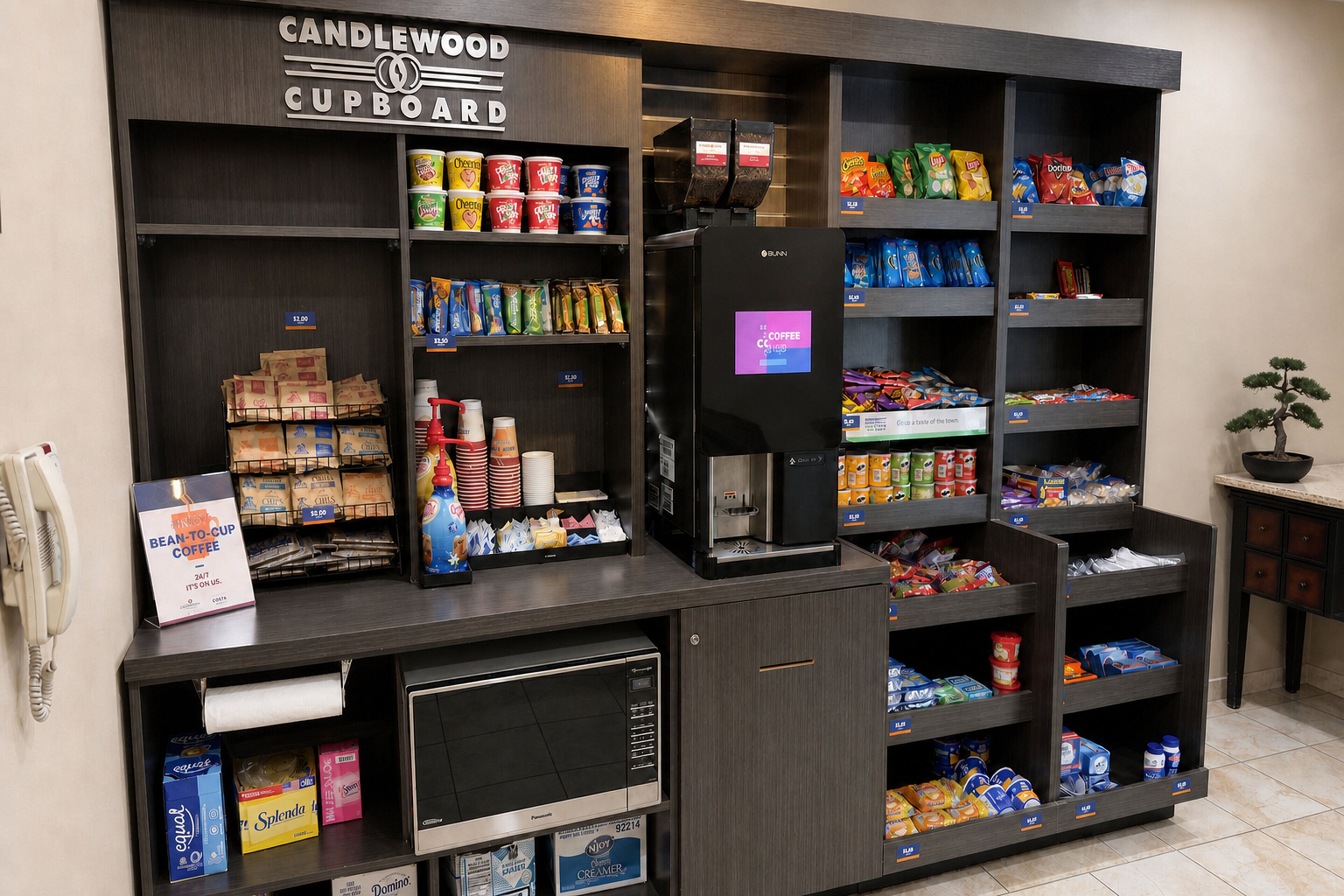 A coffee shop kiosk with a variety of coffee beans, snacks, and a coffee machine.