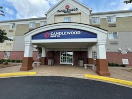 Entrada de un hotel con un cartel que dice 'Candlewood Suites'.