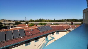 A residential area with multiple houses featuring red-tiled roofs and solar panels.