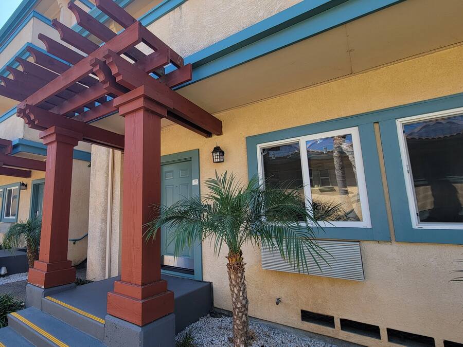 Un edificio con un'area di ingresso coperta, una porta blu e il numero 133.
