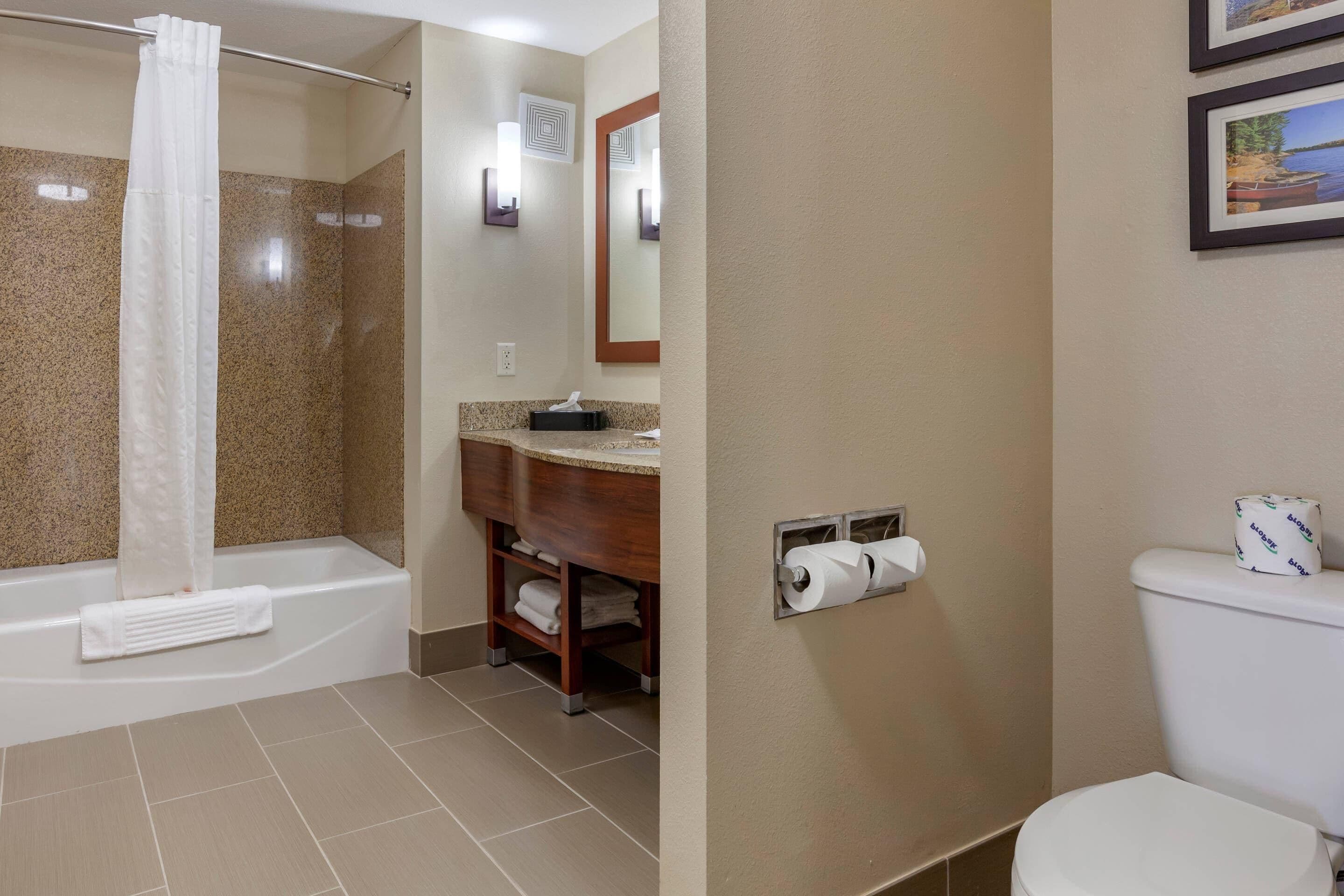 Een badkamer met een douche, toilet en wastafel.