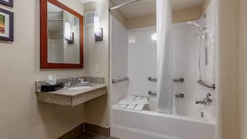 A bathroom with a sink, mirror, shower, and towel rack.