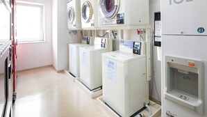 Une laverie équipée de plusieurs machines à laver et d’un sèche-linge.