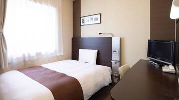 Ein Hotelzimmer mit einem großen Bett, einem Schreibtisch mit Computer und Telefon, einem Fernseher und einem Bild an der Wand.