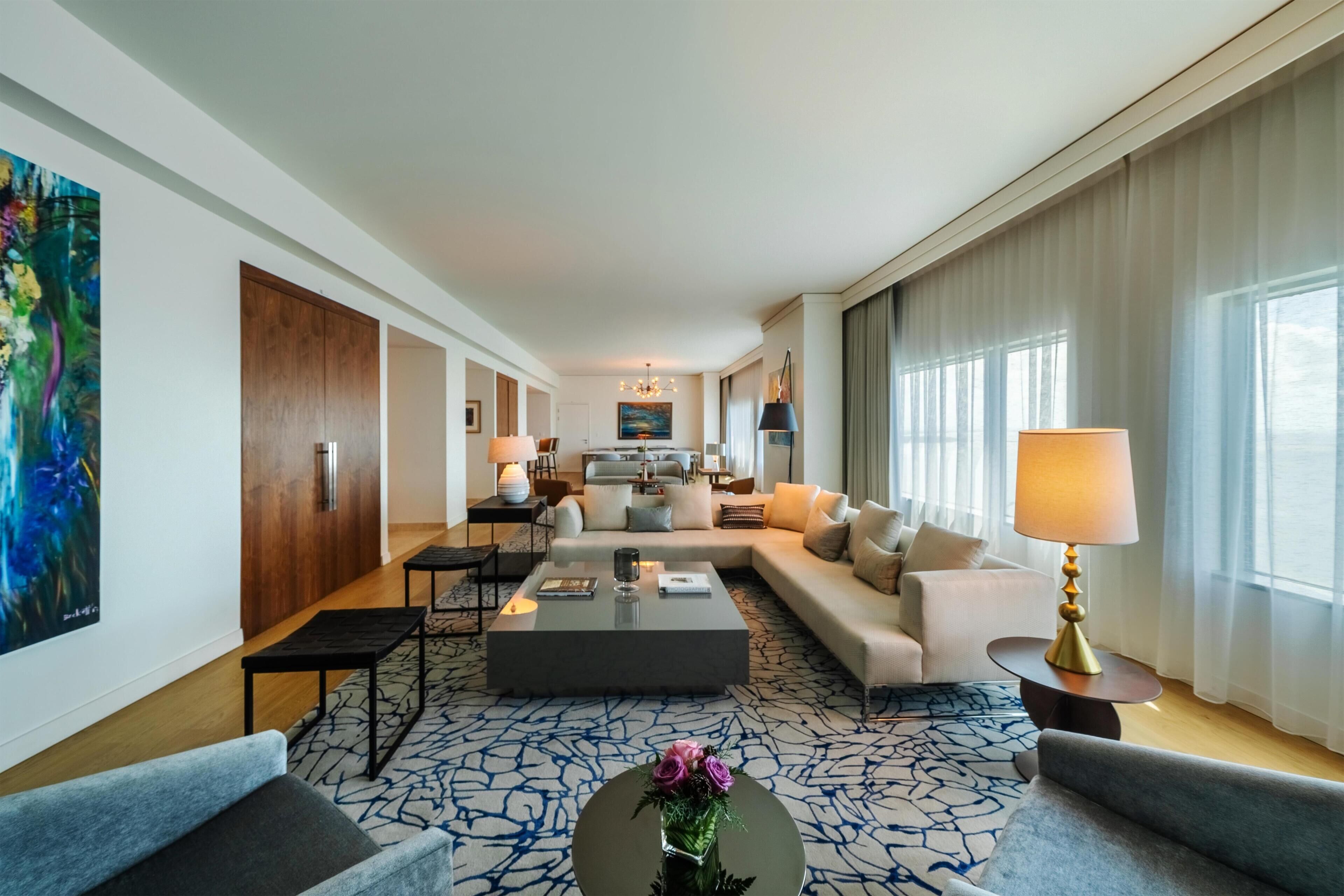 A spacious living area with a sofa, coffee table, and a dining table.