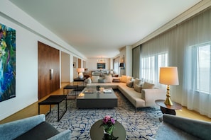 A spacious living area with a sofa, coffee table, and a dining table.