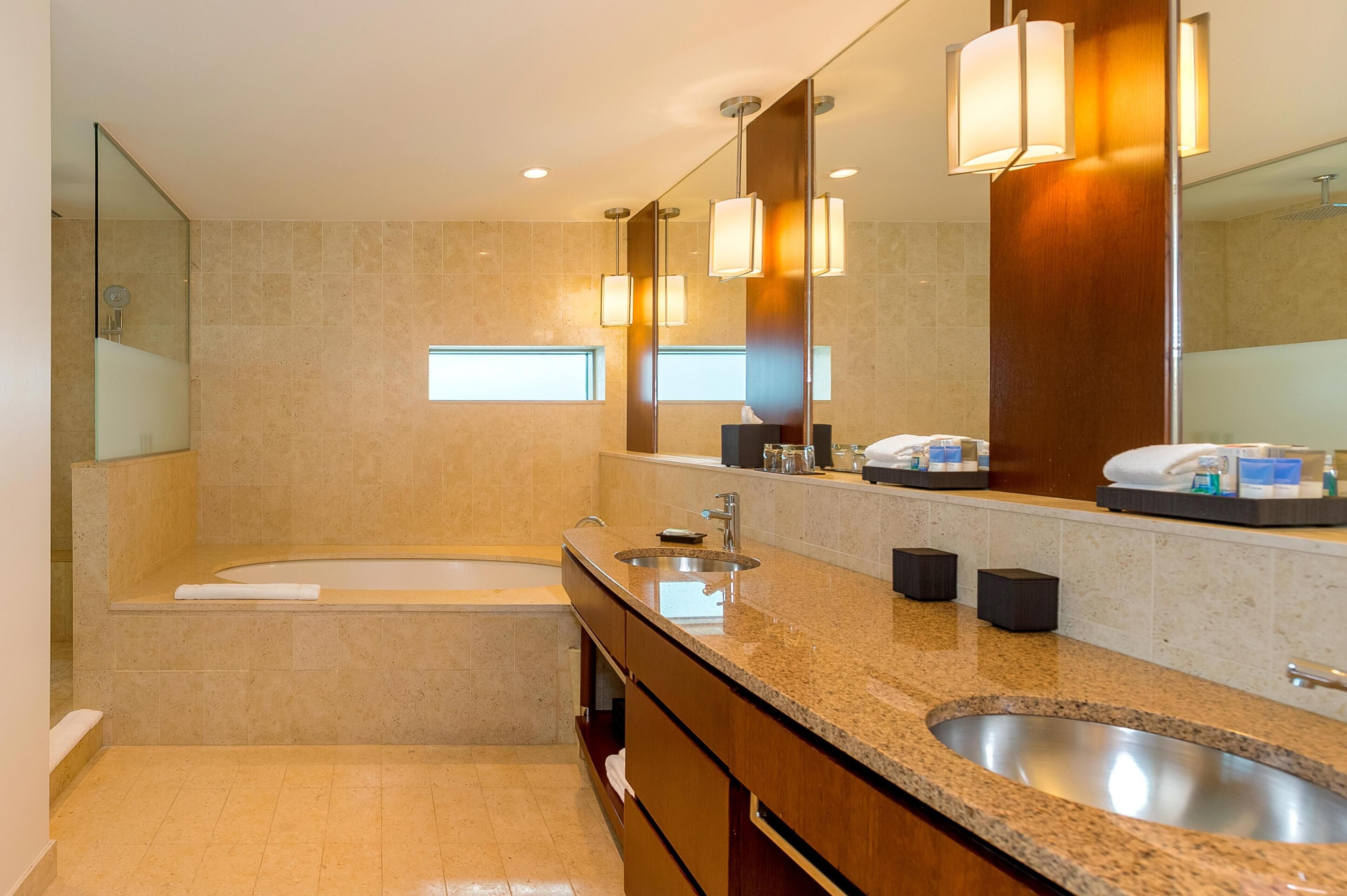 Un bagno moderno con una vasca, un lavandino e un grande specchio.