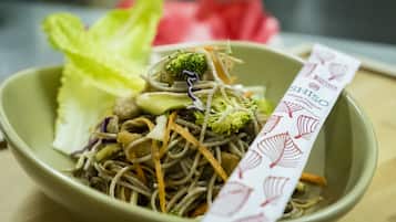 Un tazón de fideos de fusión asiática con vegetales y una etiqueta.
