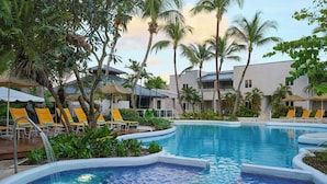 A pool area with lounge chairs and palm trees. - Waves Resort & Spa, Barbados, An Autograph Collection® All-Inclusive Resort (Prospect)