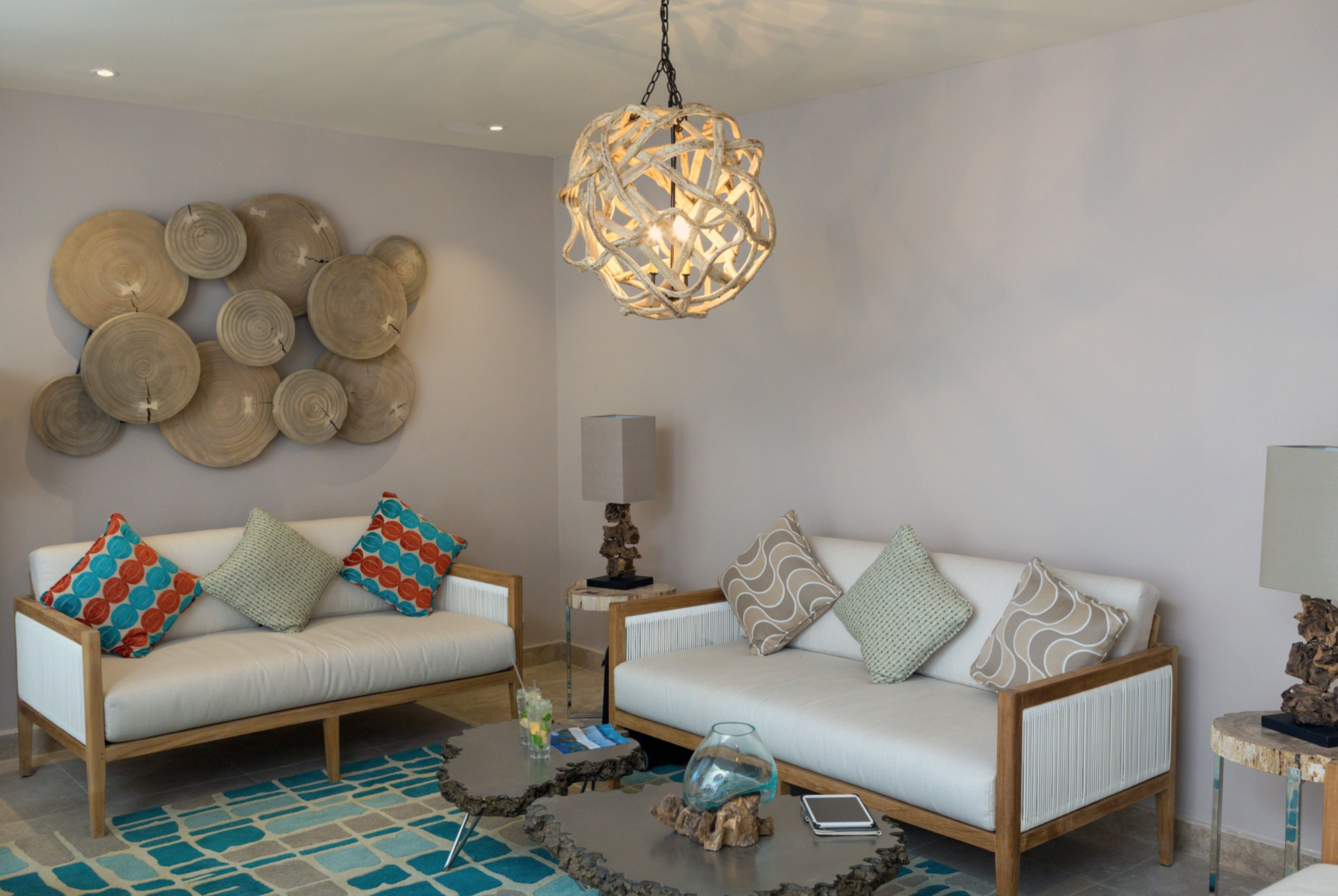 A modern living room with two sofas, a coffee table, and a unique spherical light fixture.