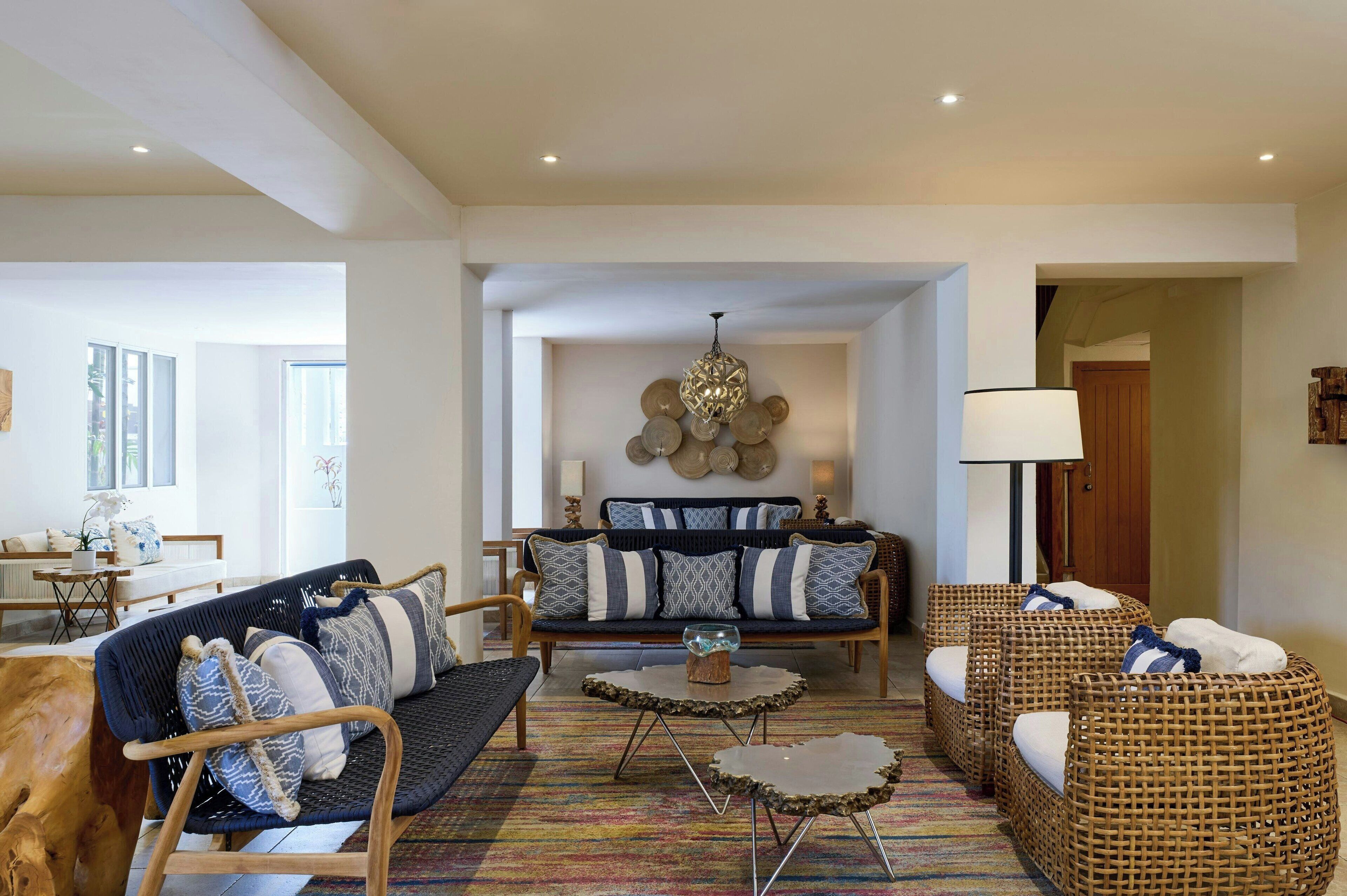 A spacious living room with a sofa set, two side chairs, a coffee table, and a floor lamp.