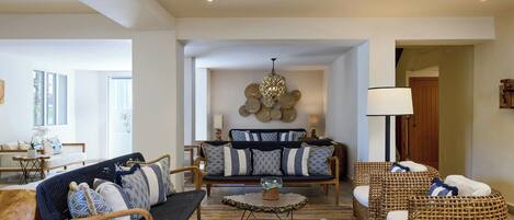 A spacious living room with a sofa set, two side chairs, a coffee table, and a floor lamp.