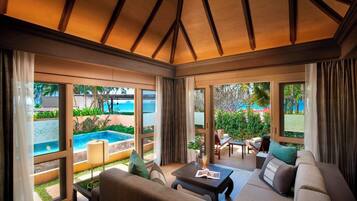 A spacious living area with a pool view, large windows, and a ceiling with wooden beams.