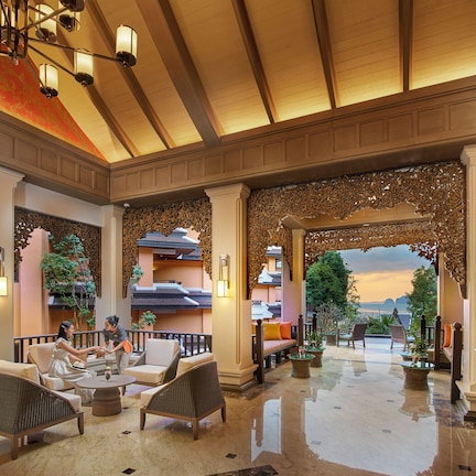 A spacious lobby with a high ceiling, ornate columns, and a view of the mountains.
