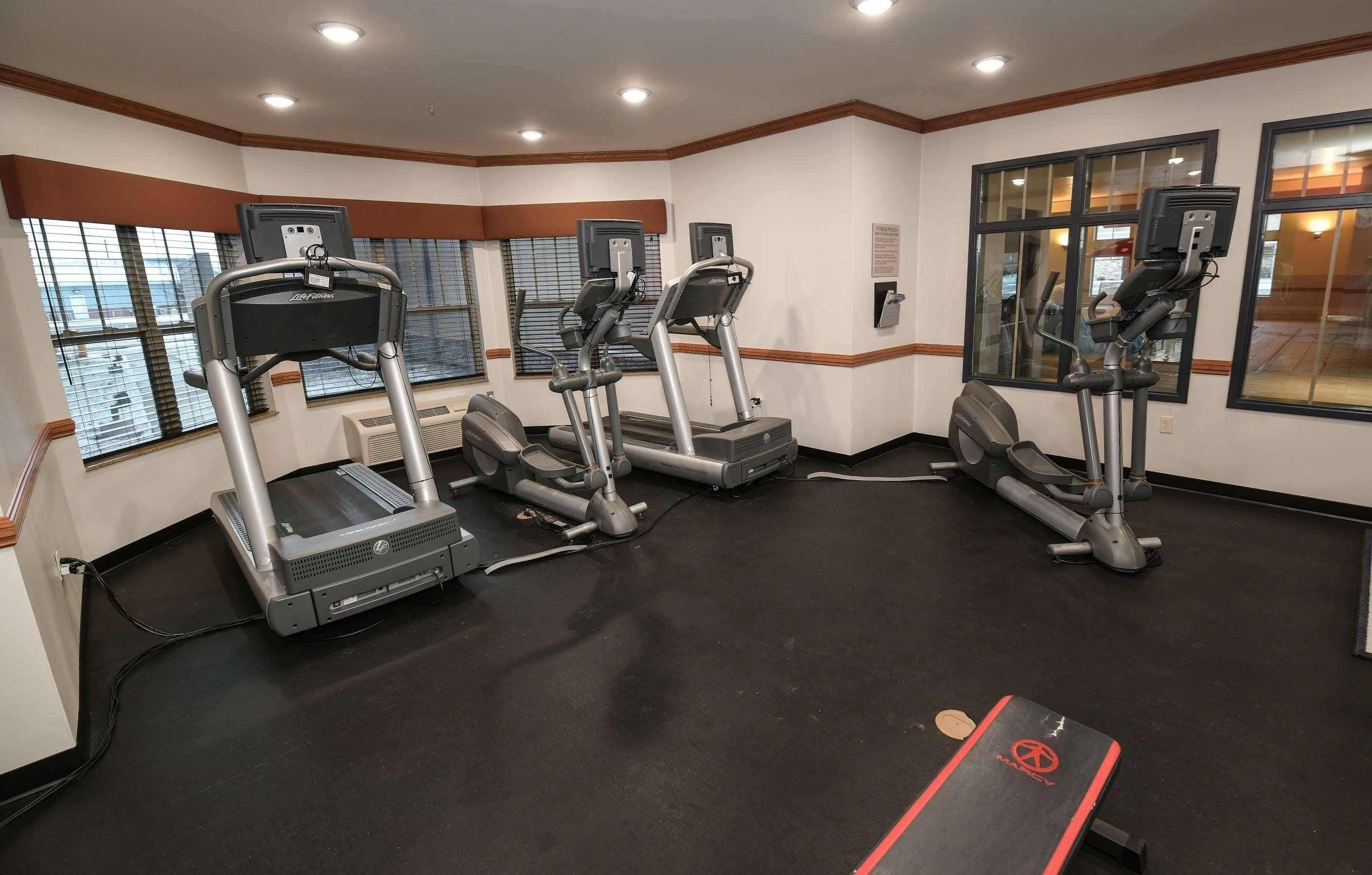 Una palestra con tapis roulant, cyclette ellittiche e una bicicletta stazionaria.