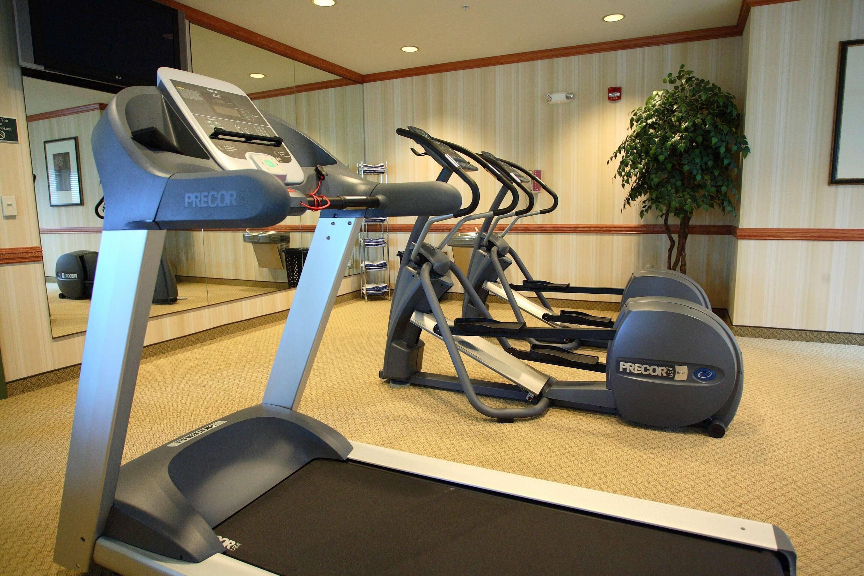 A hotel fitness room with a treadmill, elliptical, and stationary bike.