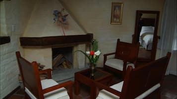 Una habitación acogedora con chimenea, muebles de madera y un cuadro en la pared.