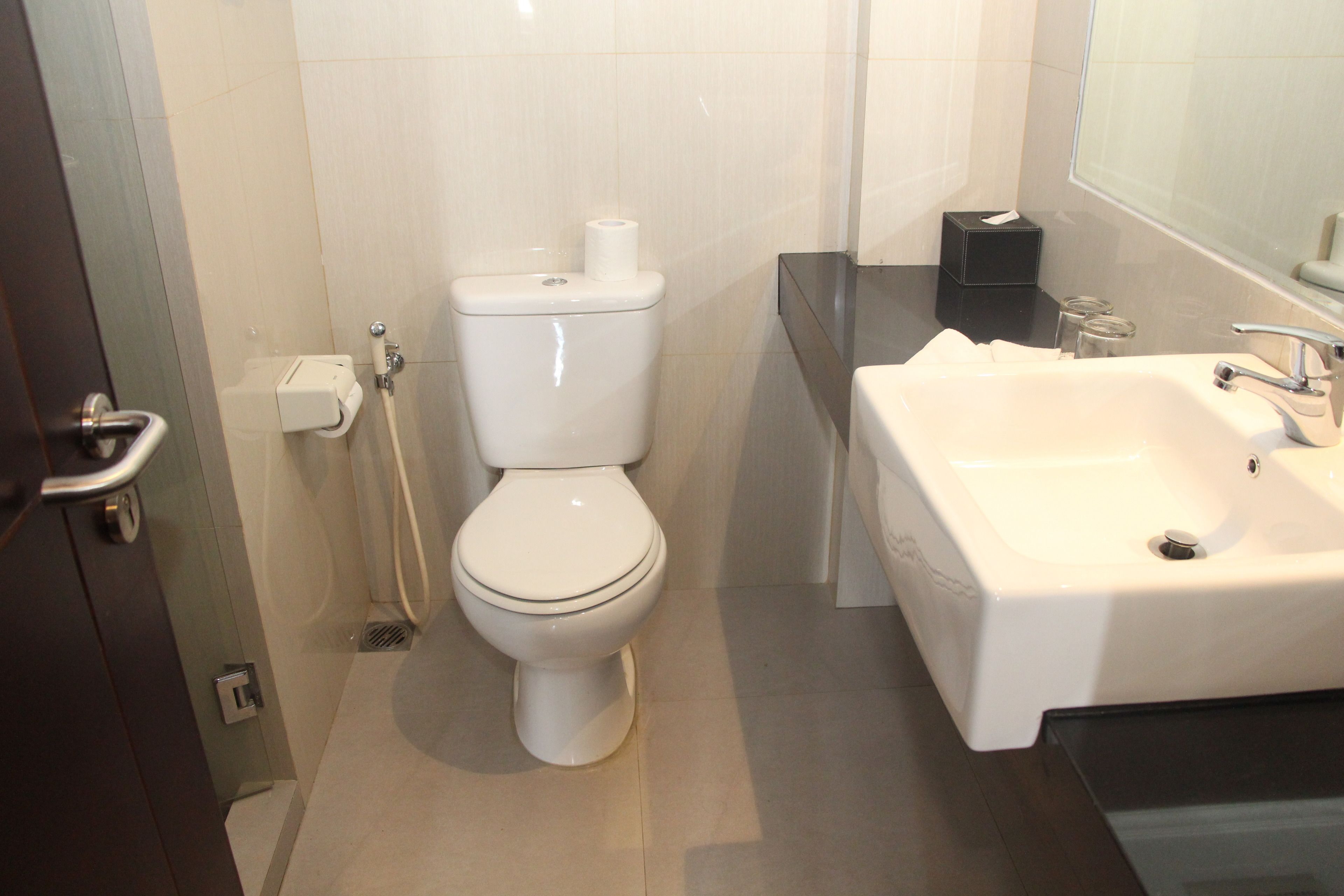 Un baño moderno con inodoro, lavamanos y ducha.