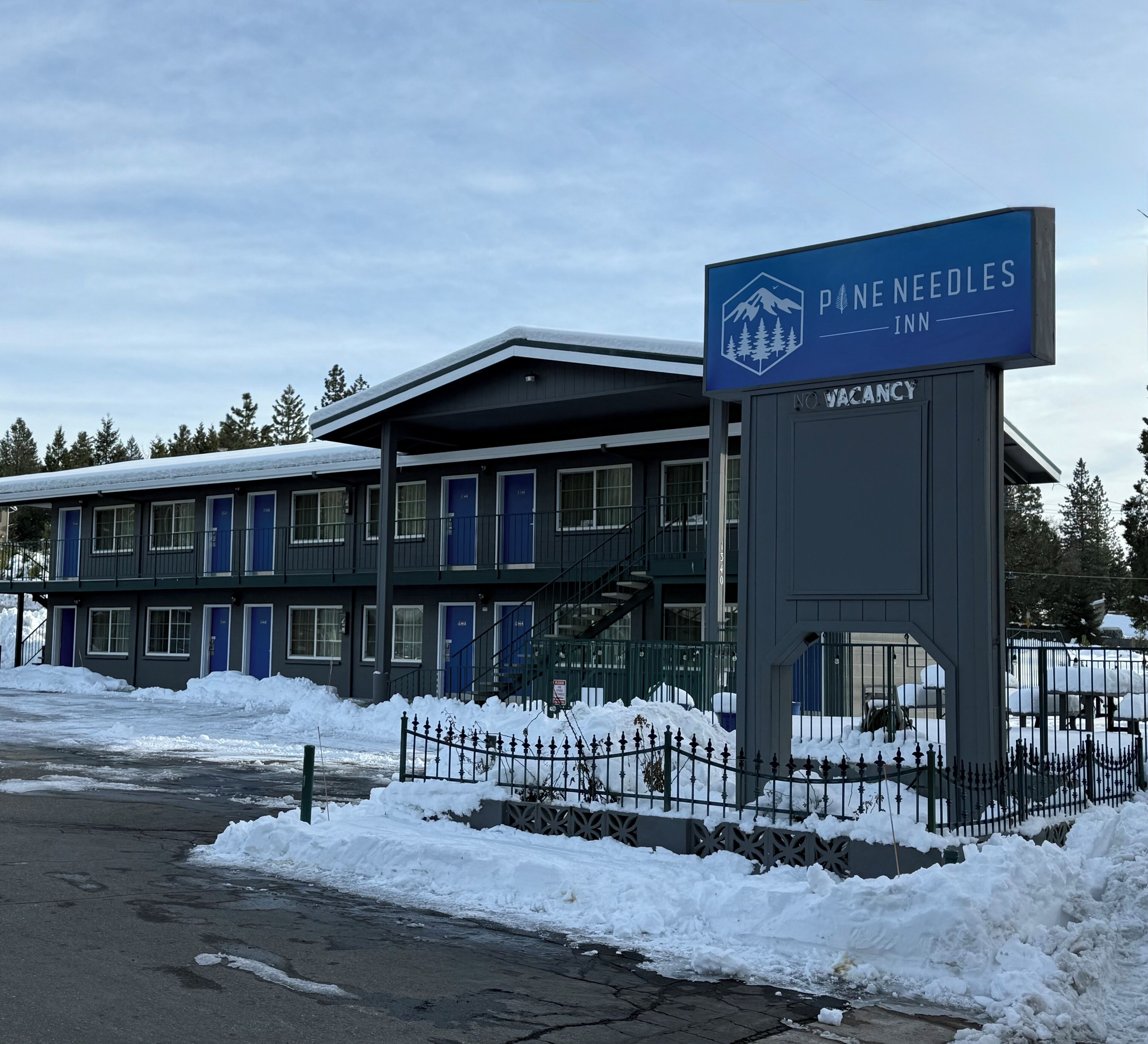 A building with a sign reading "Pine Needles Inn" and a "No Vacancy" sign.
