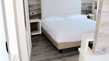 Une chambre à coucher avec un lit, des tables de chevet et une armoire.
