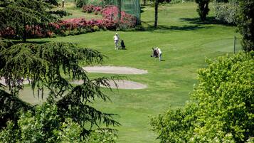 A golf course with a well-maintained green, sand bunkers, and lush landscaping.