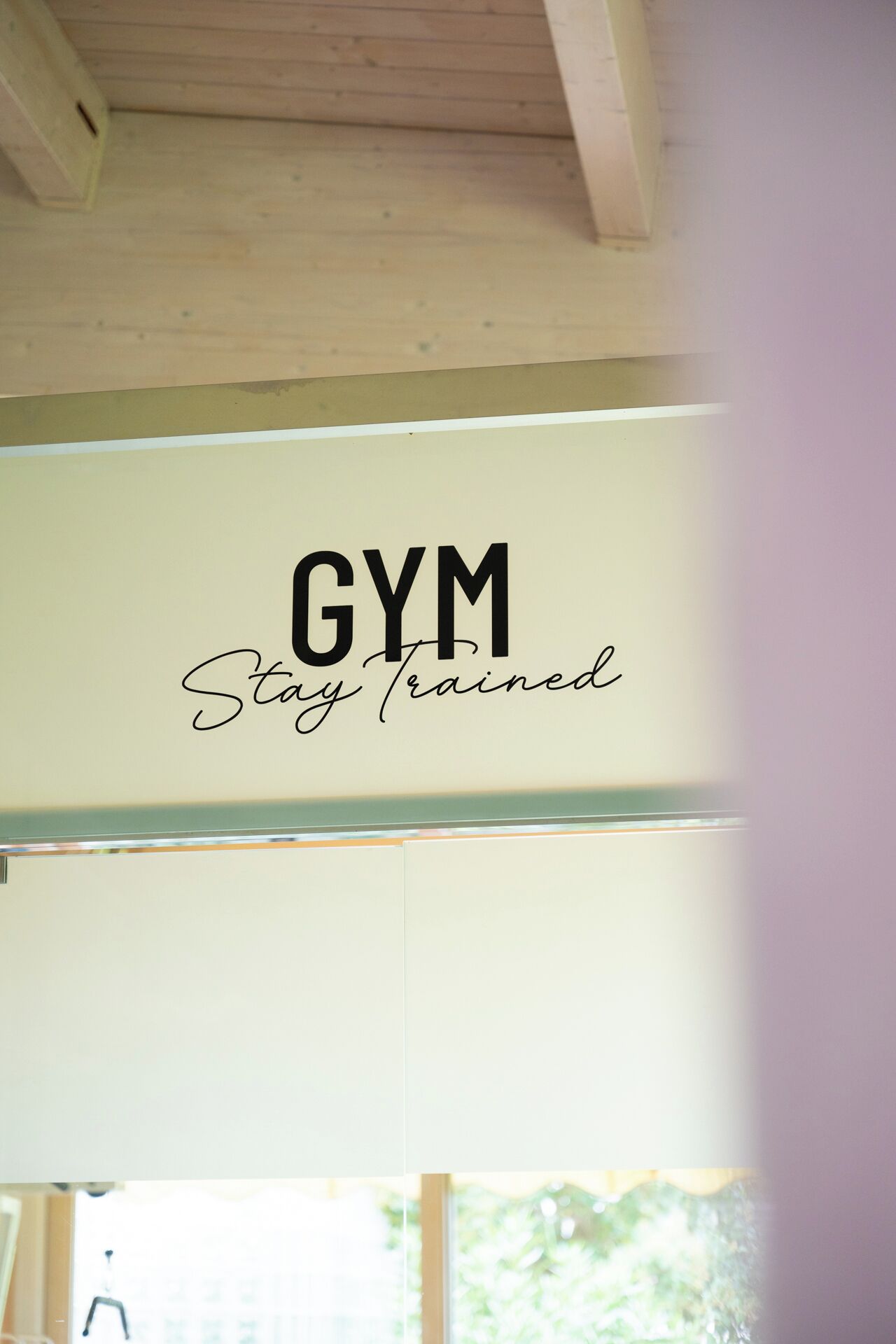 Un letrero con el texto 'GYM Stay Trained' en una pared.