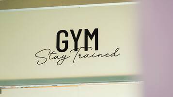 Un letrero con el texto 'GYM Stay Trained' en una pared.