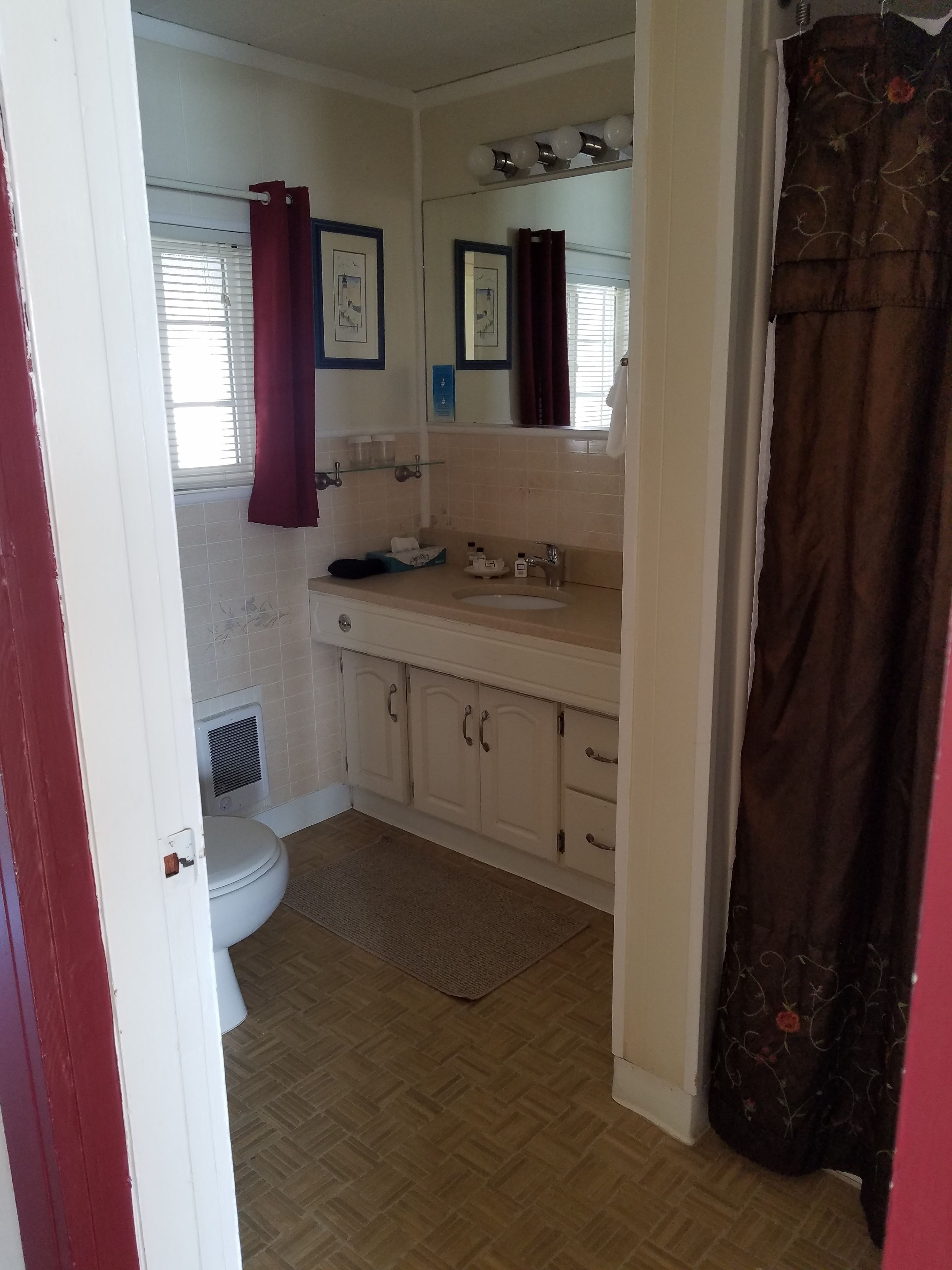 A bathroom with a toilet, sink, and shower area.