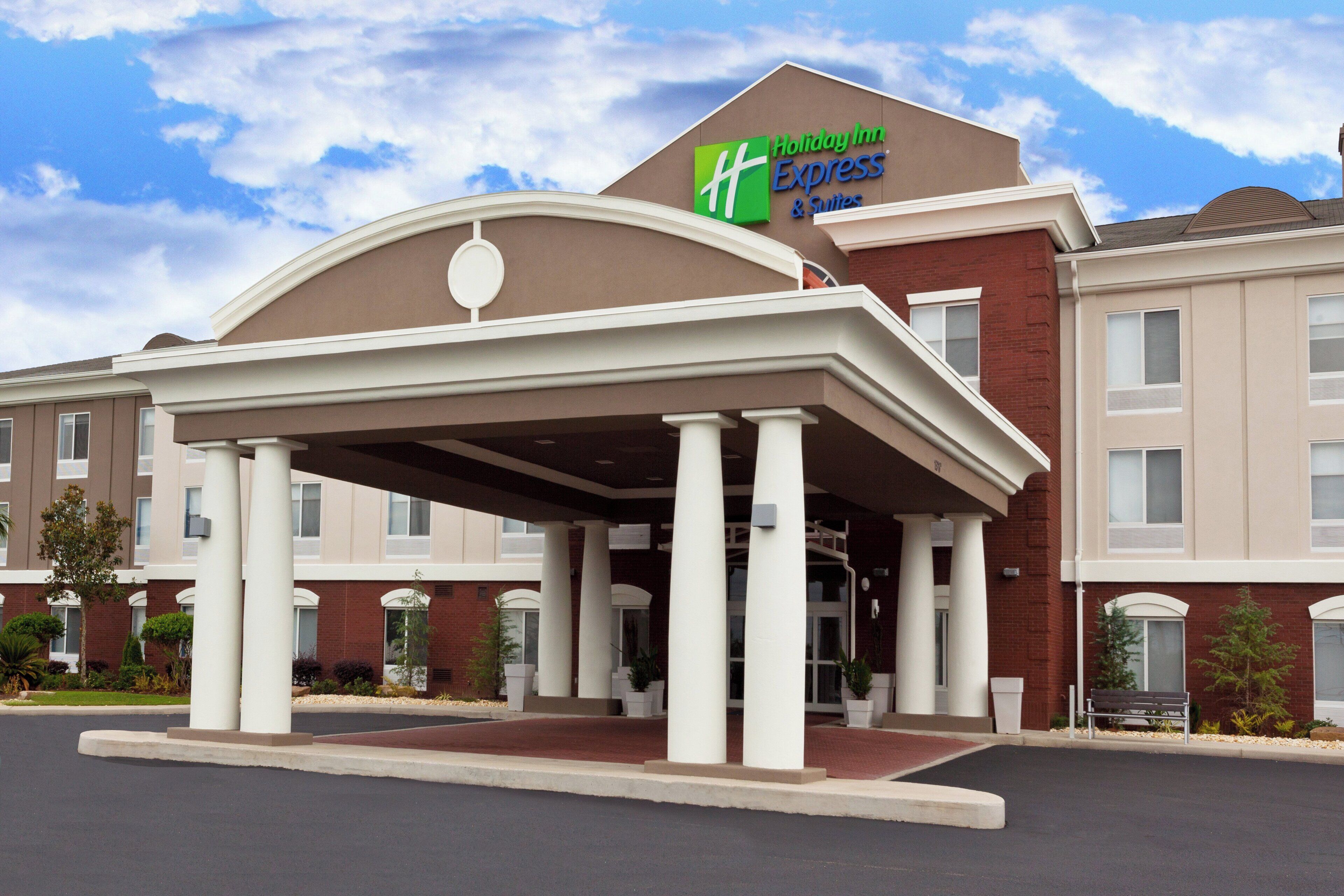 Edificio de Holiday Inn Express & Suites con entrada cubierta y varias ventanas.