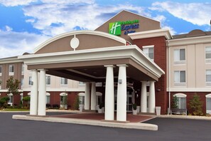 A Holiday Inn Express & Suites building with a covered entrance and multiple windows.