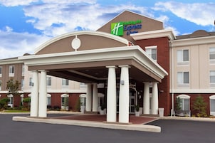 Edificio de Holiday Inn Express & Suites con entrada cubierta y varias ventanas.