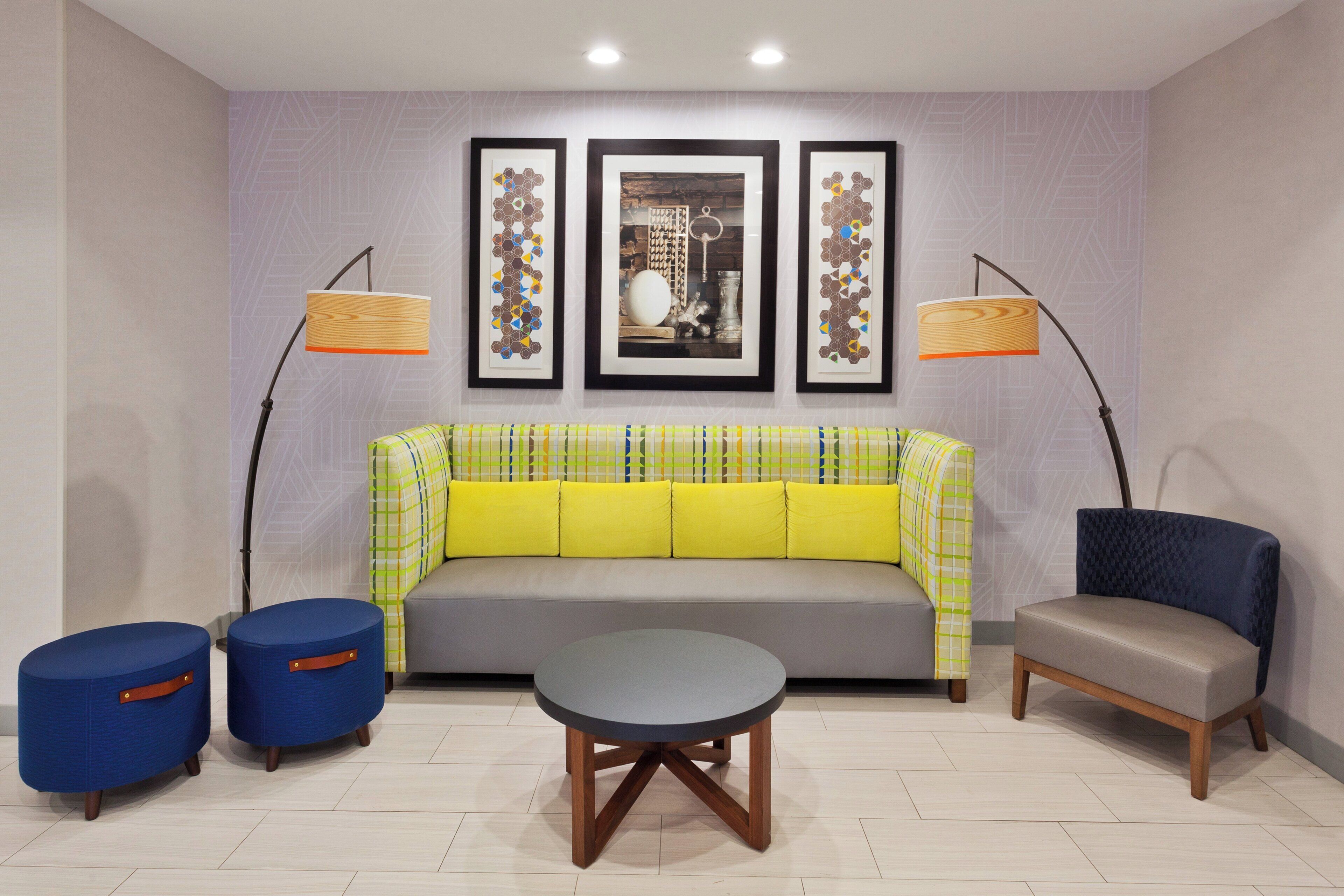 Una sala de estar moderna con un sofá, dos sillones, una mesita de centro y dos lámparas de pie.