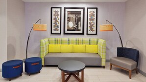 A modern living room with a sofa, two armchairs, a coffee table, and two floor lamps.