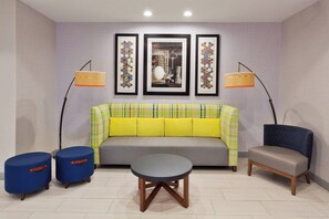 A modern living room with a sofa, two armchairs, a coffee table, and two floor lamps.