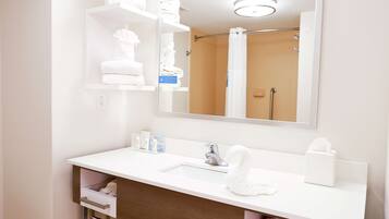 Un baño moderno con un lavamanos blanco, un espejo y una ducha.