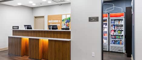 A reception area with a wooden reception desk, a sign reading "Welcome to Hampton," and a "Treats Shop" sign.