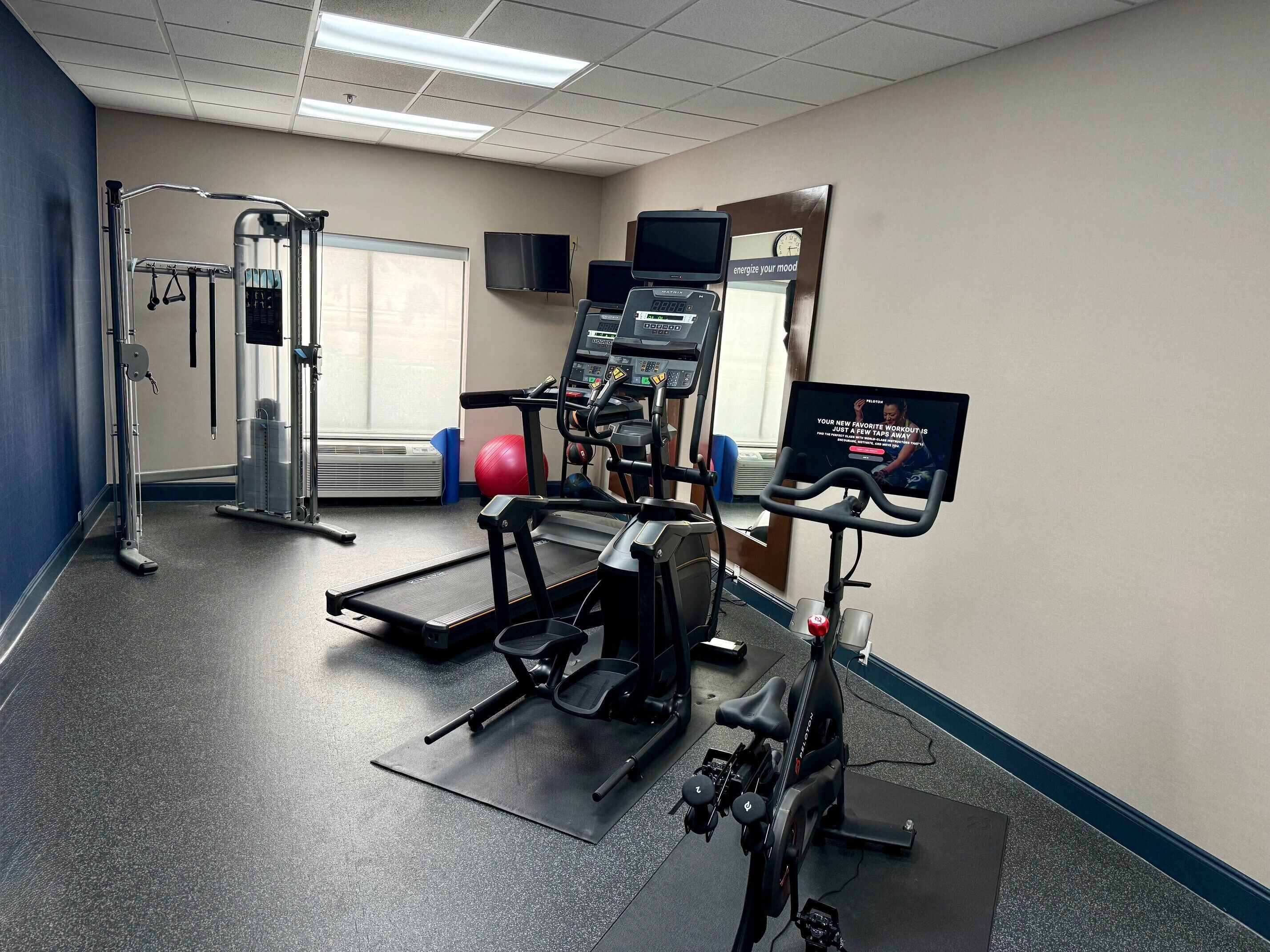 A gym with exercise equipment, a treadmill, and a stationary bike.